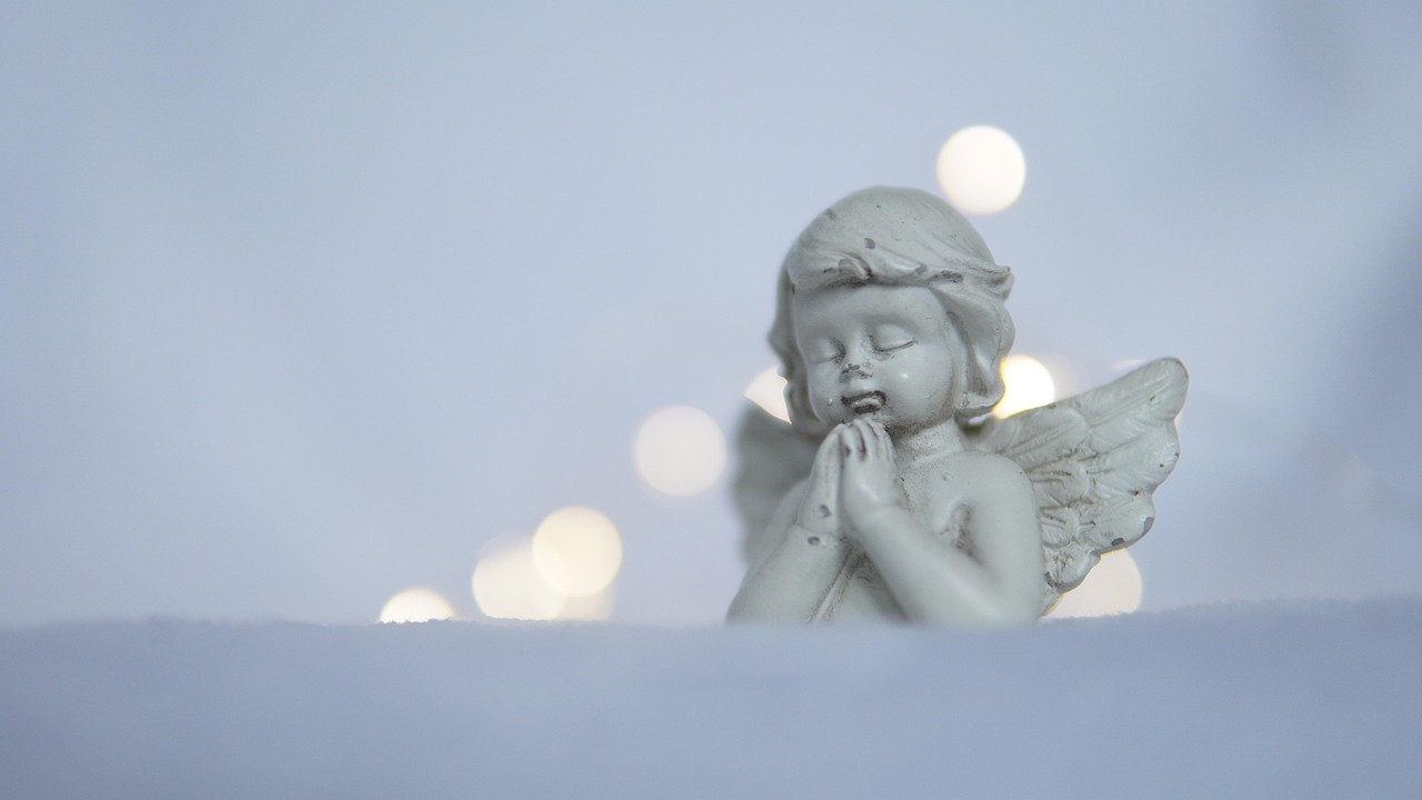 Immagine di un angelo che veglia su un paesaggio sereno al sorgere del sole, simbolo di protezione divina.