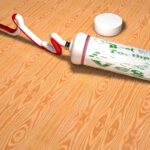 Dentifricio applicato su un graffio di legno, con un panno a fianco per la lucidatura.