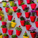 Giardino verticale fai da te realizzato con materiali di riciclo, piante verdi su una struttura innovativa.