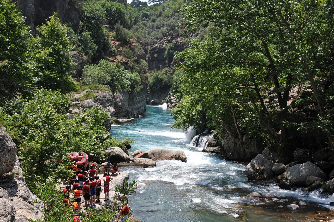 Gruppo di persone in canoa mentre fanno rafting in un fiume italiano circondato da natura.