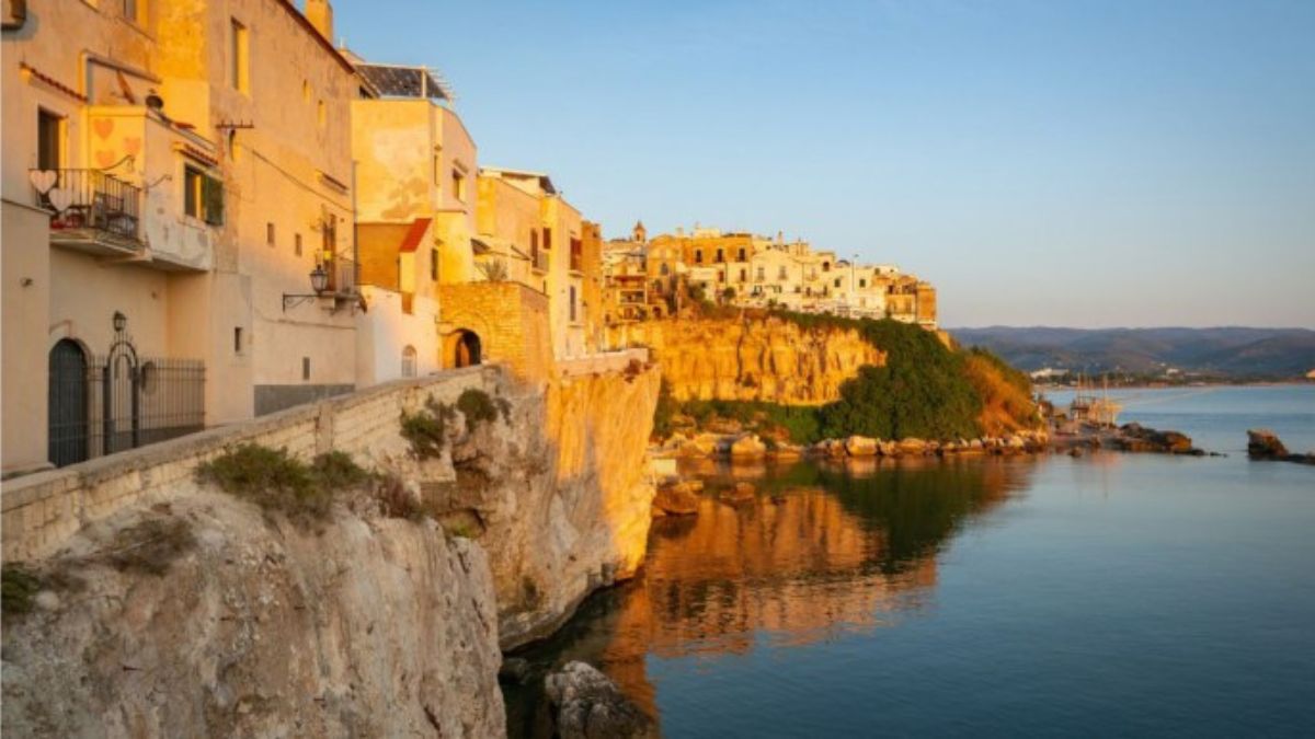 Spiaggia nascosta in Calabria con acque cristalline e scogliere verdi, ideale per una fuga tranquilla.